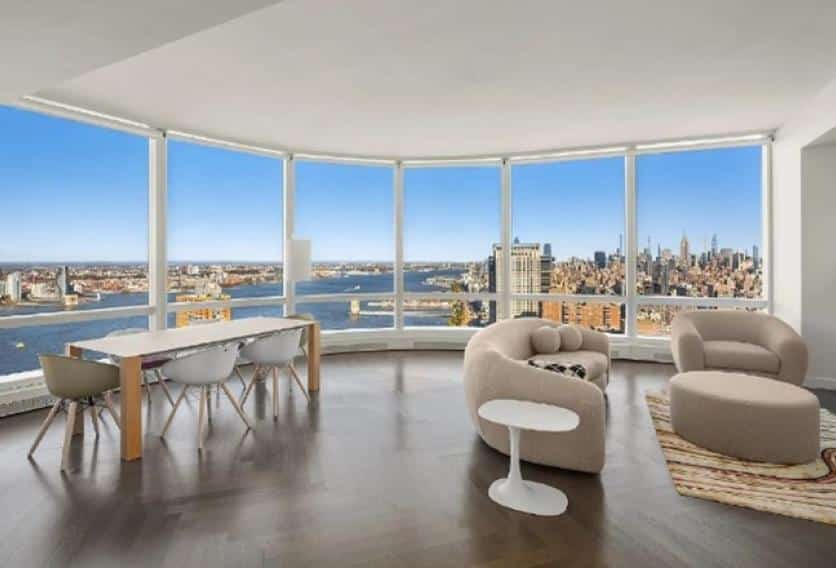 A cozy living room with large windows showcasing a stunning view of the city skyline