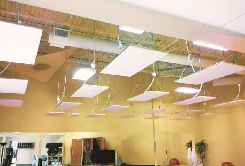 A spacious yoga studio with several ceiling lights illuminating a table in the center