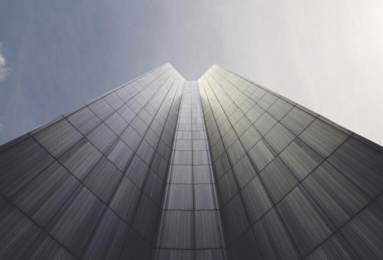 A view looking up at the top of a tall building, showcasing its height against the sky