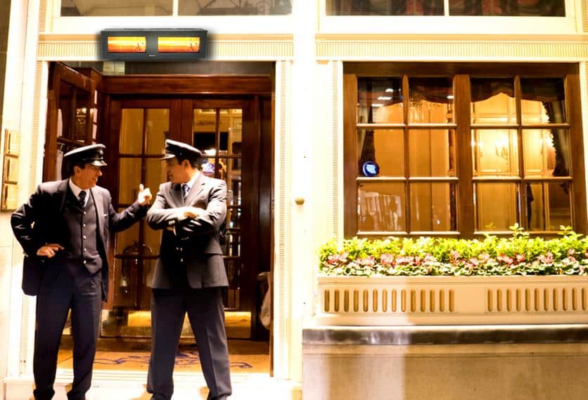 Two uniformed men are positioned at the hotel entrance talking