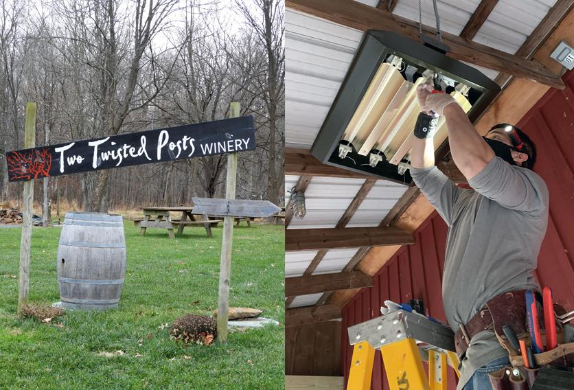 two twisted posts winery sign next to worker installing heater unit